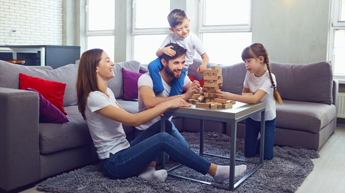 young family playing Jenga in new home